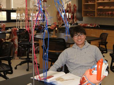 student sitting at a table in a science lab