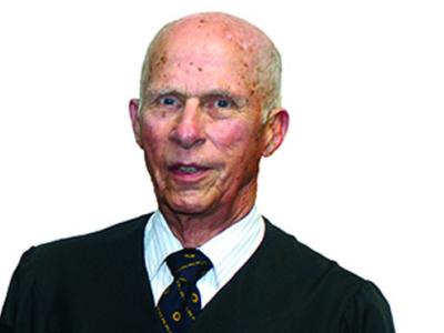 James Koller wearing a black coat and tie