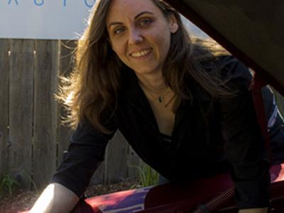 Kate Jonasse standing next to a car, underneath the hood