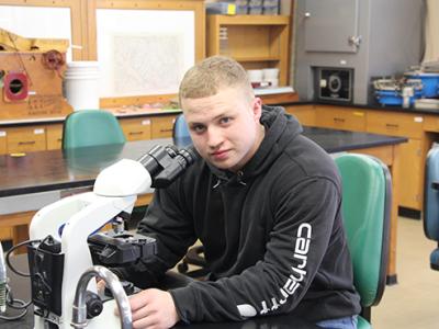 Nathan Martin uses the microscope in a lab