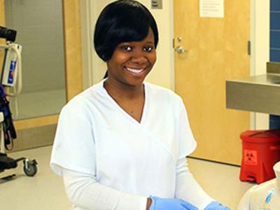 Olufunmilola Olojede in a nursing lab with blue gloves on