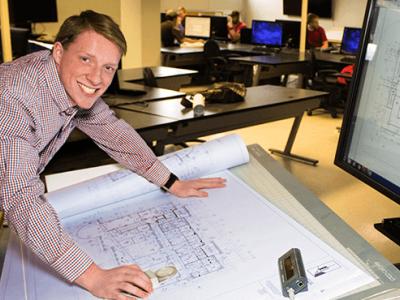 Robert Mahany standing over a drawing on a table