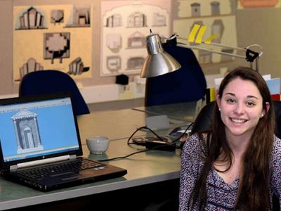 Sarah Travers sitting at a table with a laptop