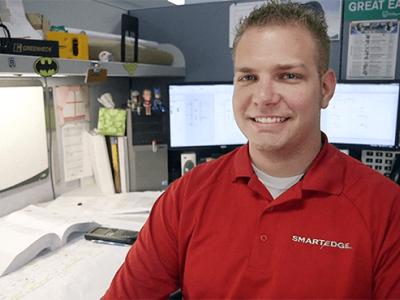 Taylor Battaglia sitting in his cubicle at work