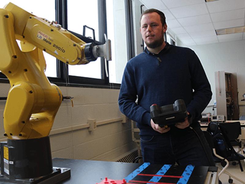 student holding a remote with a piece of equipment