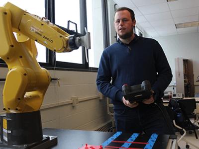 student holding a remote with a piece of equipment