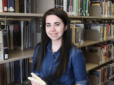 Kyra Hancock in front of a book case