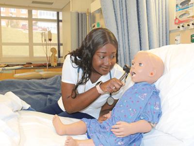 student with a doll in a lab