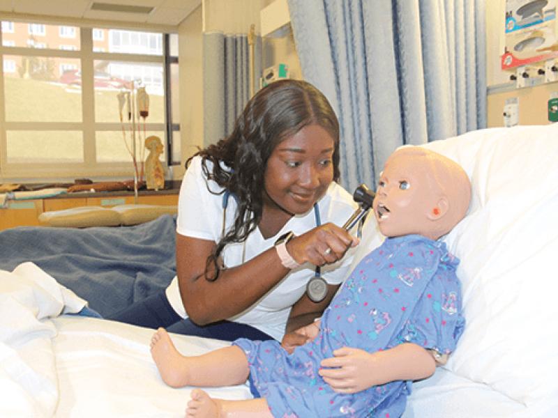 student with a doll in a lab