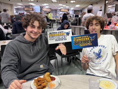 students smiling holding First-Generation student signs