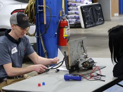 alumnus speaks with a current student at a competition.