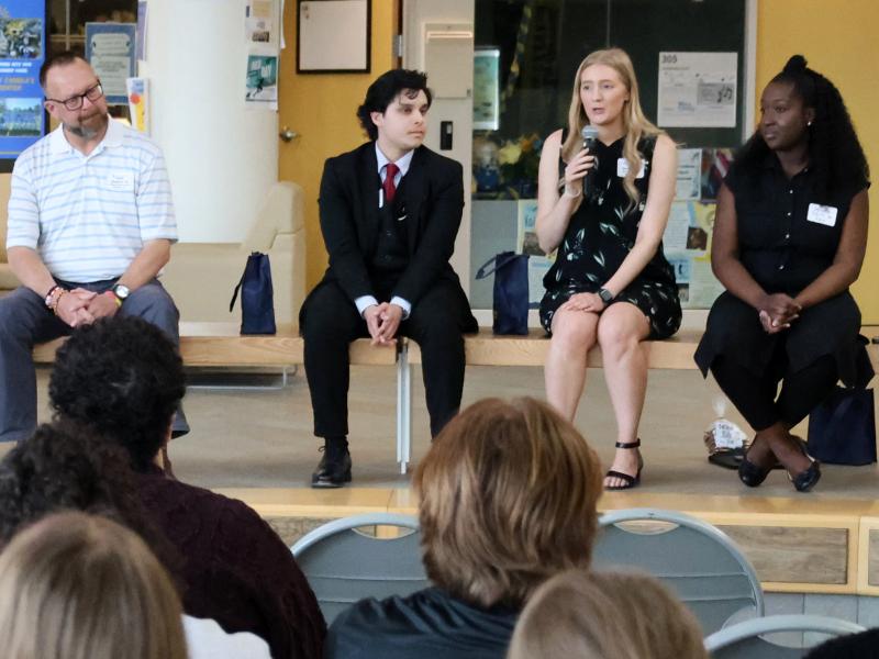 Leyah speaks with current students at a networking event.