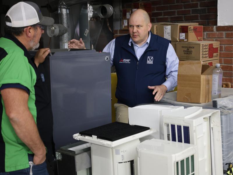 An instructor talks about equipment with a donor.