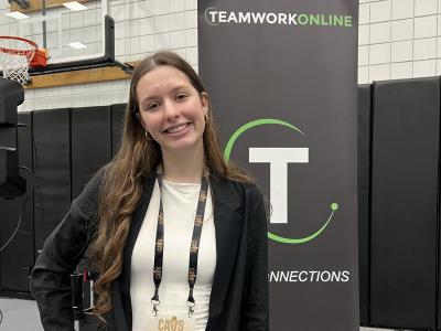 Student posing near a sign at an event with the Cleveland Cavaliers