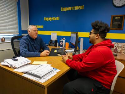 Advisor speaks with a student in his office