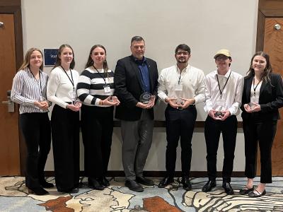 students pose with their award following competition.