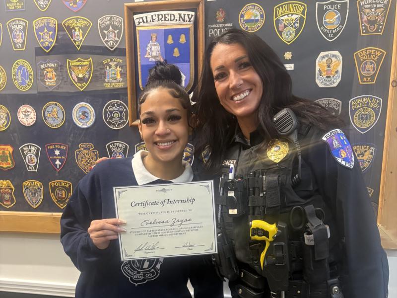 Student poses with Officer after completing her internship with the Police Department