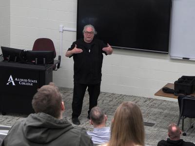 Dean Lyons speaks with students in a lecture hall