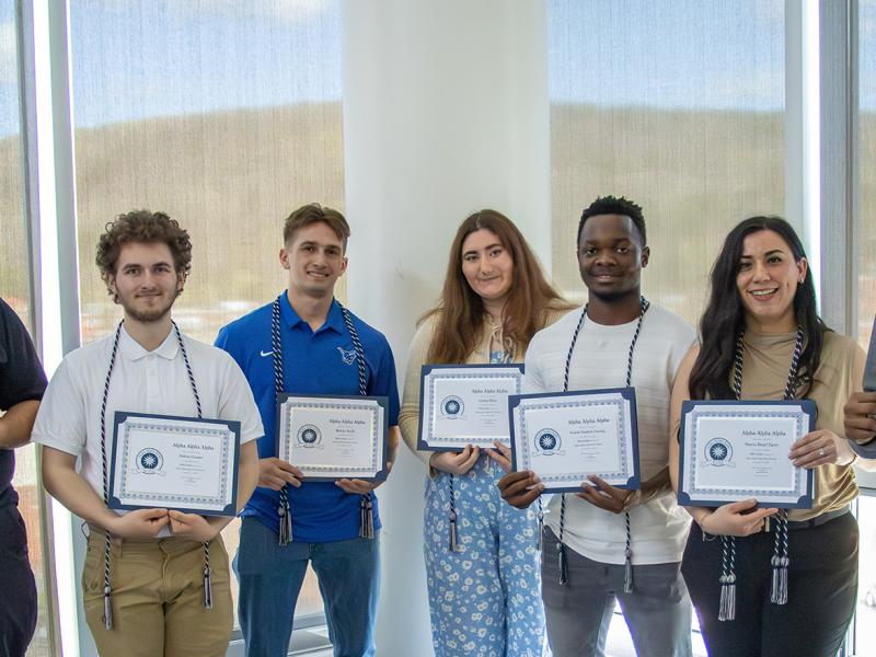 the inaugural class of Alpha Alpha Alpha shows off their awards