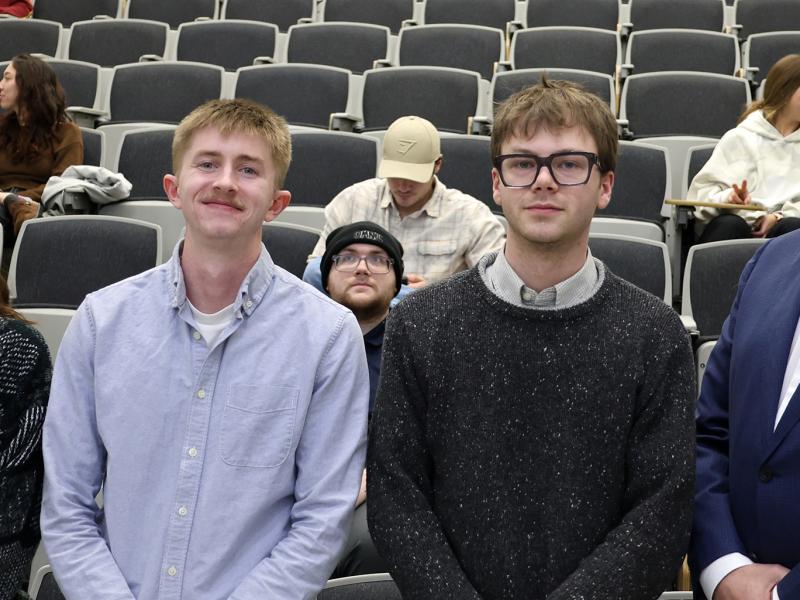 Students stand with their professor after receiving an award