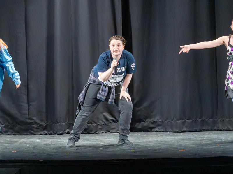 student performs a song on a stage