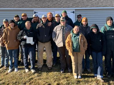 Logging sports team poses after their home meet