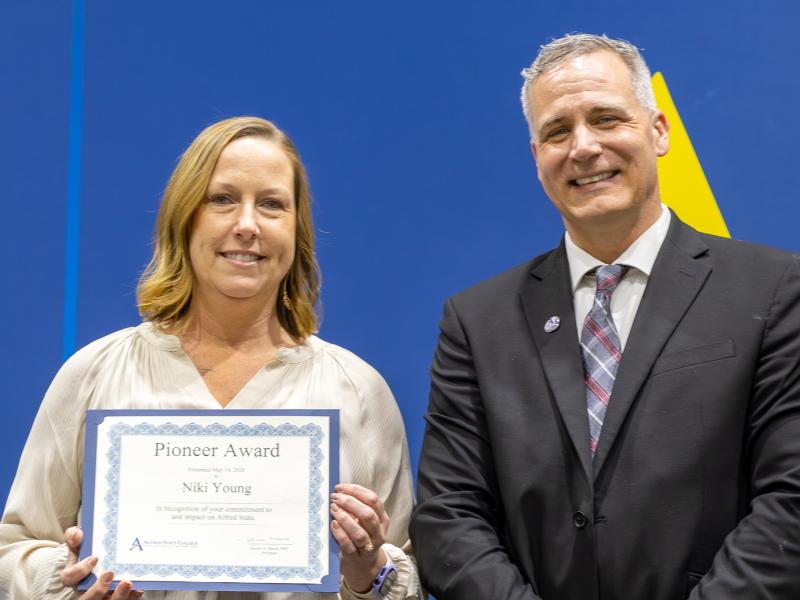 Niki Young shows her certificate while standing with Dr. Mauro.