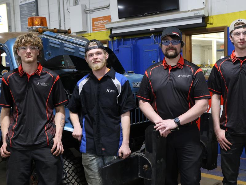 students participating in the Great Race stand in front of their tow truck