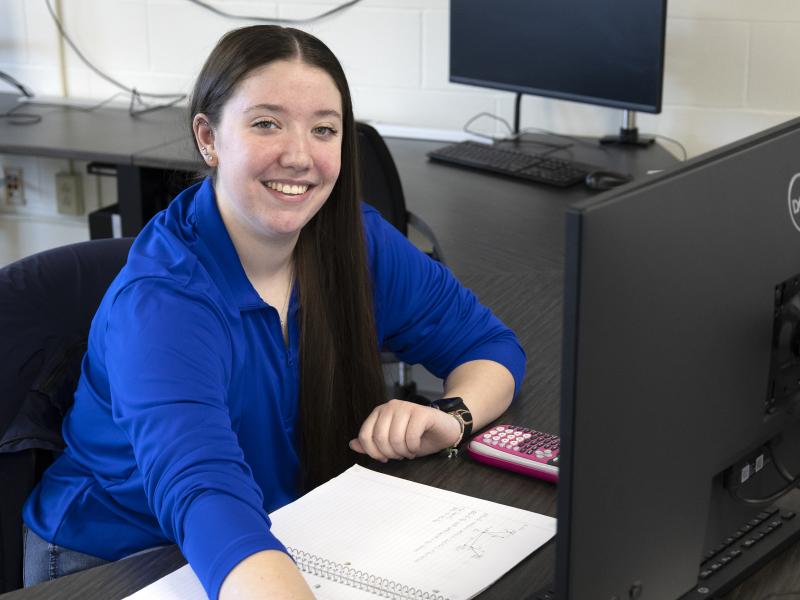 smiling student working on a computer