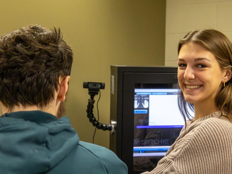 student takes finger prints of another student in a lab.