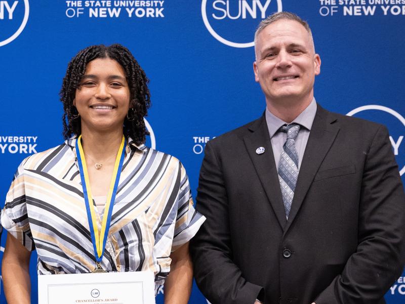 Student poses with award with Dr. Mauro