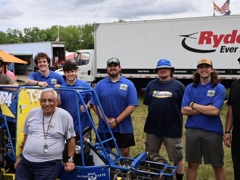 The Alfred State SAE Baja poses in front of their car