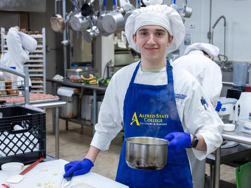 student shows off his work in the kitchen
