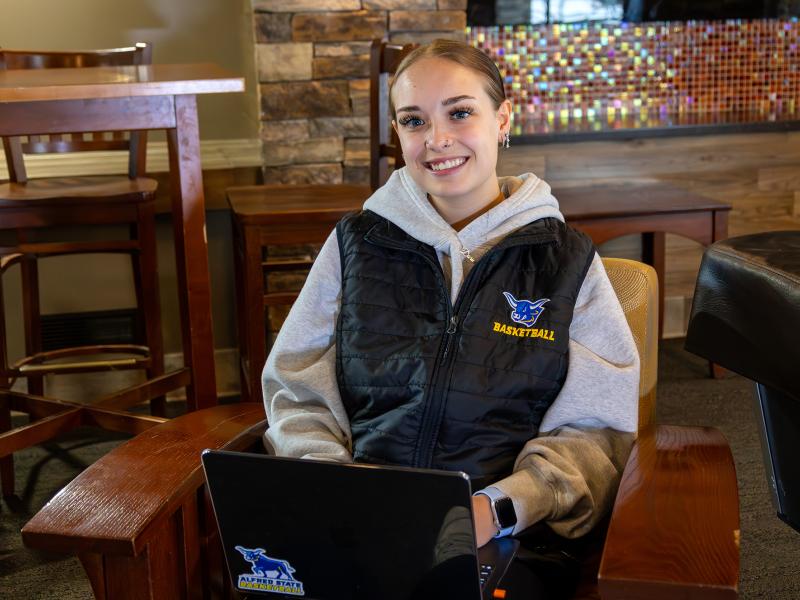 student sitting in a lounge with her laptop