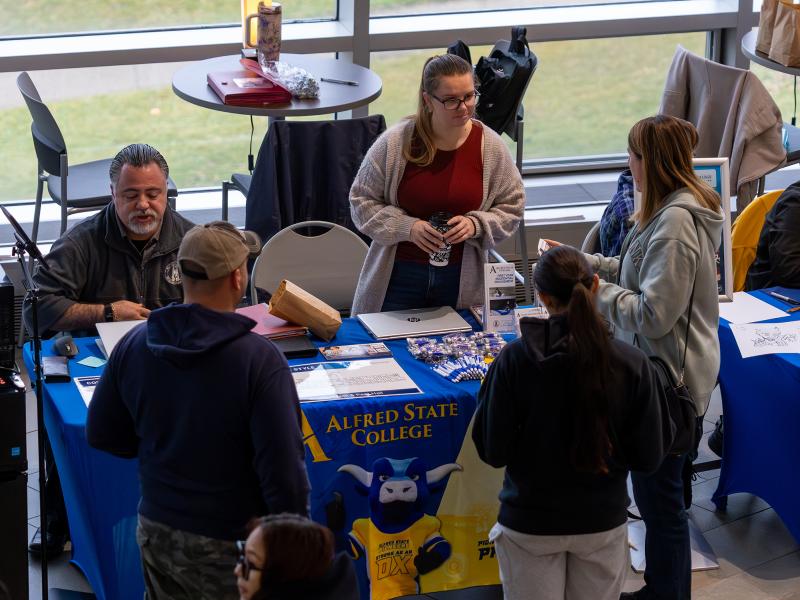 students talk to representatives from residence life at an open house