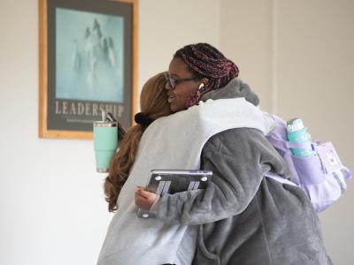 Students hug outside a classroom