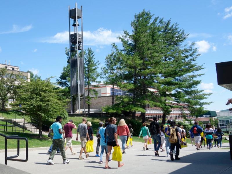 Students walk down the spine of campus by the Bell Tower.