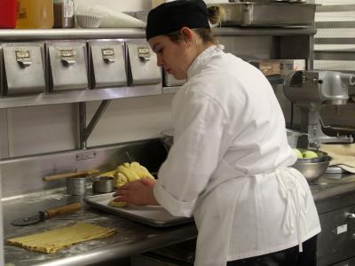 An Alfred State Culinary Arts student works in the kitchen.