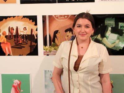 student stands in front of her artwork 