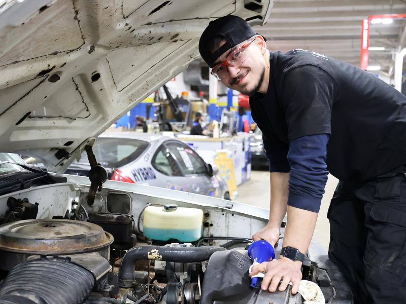 student working on a car