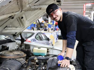 student working on a car