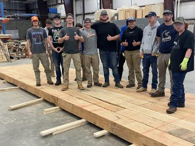 Building trades students stand on a bridge they constructed