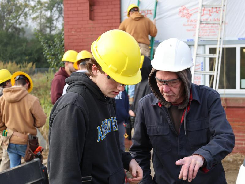student works with an instructor at a job site