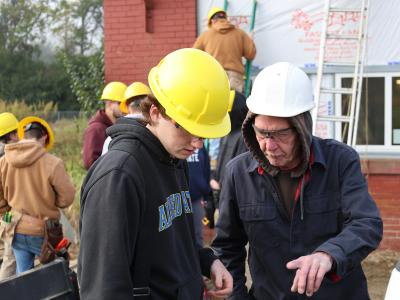 student works with an instructor at a job site