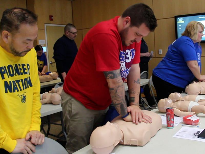 Alfred State Admissions Counselor Doug Tay (middle of picture) practice CPR compressions during a training session. 40 Alfred State employees attended the CPR/AED class held during the college Professional Development Week.