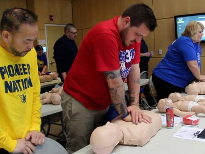 Alfred State Admissions Counselor Doug Tay (middle of picture) practice CPR compressions during a training session. 40 Alfred State employees attended the CPR/AED class held during the college Professional Development Week.