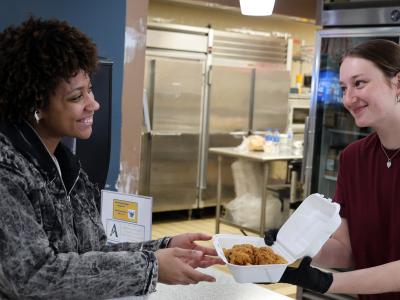A student worker serves another student food