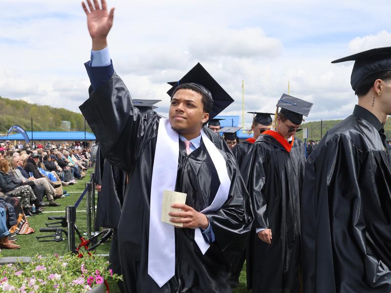 An Alfred State student waves to family during Commencement