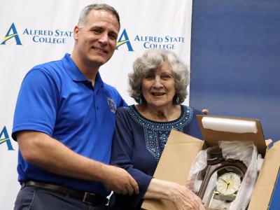 Dr. Constantine is presented a clock by Dr. Mauro