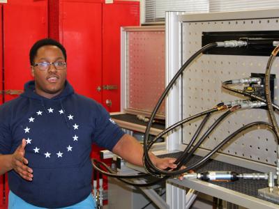 Student standing next to engineering machinery